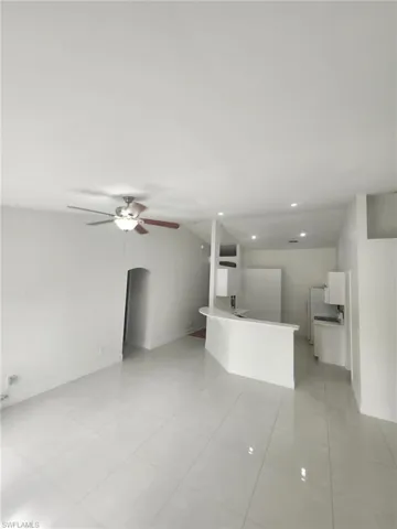 Kitchen featuring white cabinets, light tile patterned floors, and ceiling fan