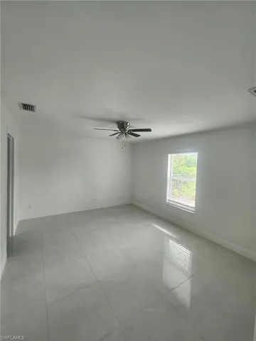Tiled empty room with ceiling fan