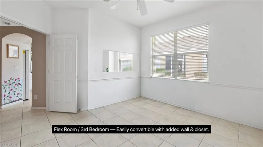 Versatile room featuring tile flooring, a large window with horizontal blinds, and a ceiling fan