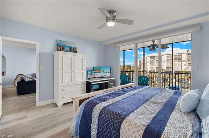 Bedroom with light wood-style flooring, baseboards, access to outside, and a ceiling fan