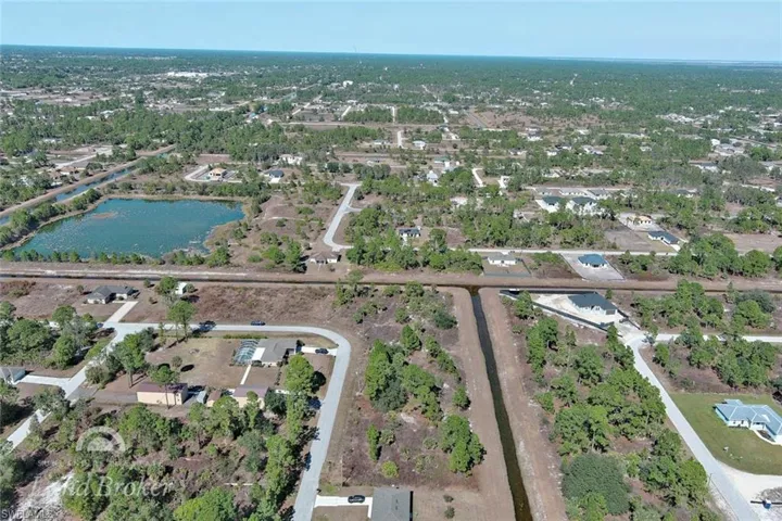 Aerial view of property and surrounding area with a nearby body of water