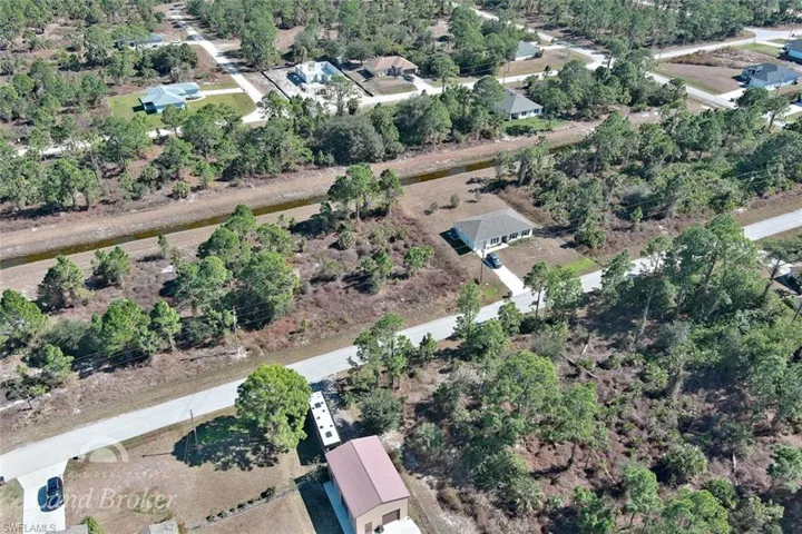 Aerial view of property's location featuring a tree filled landscape