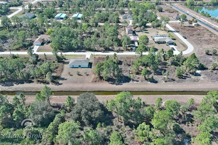 Aerial view of property's location featuring a tree filled landscape