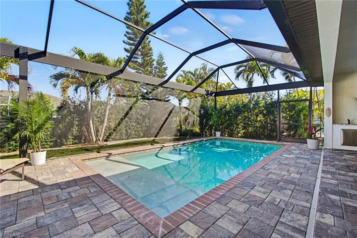 Outdoor pool with a lanai, a sunroom, and a patio area