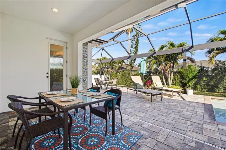 View of patio featuring a sunroom, a lanai, and outdoor dining space
