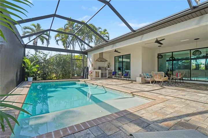 Swimming pool with a patio area, a sunroom, and a lanai