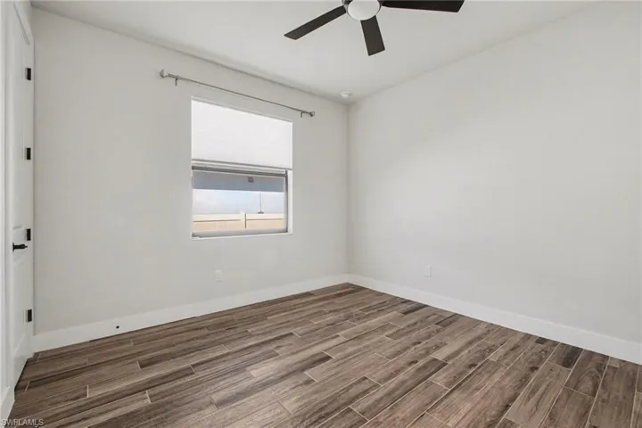 Unfurnished room featuring wood tiled floors and a ceiling fan