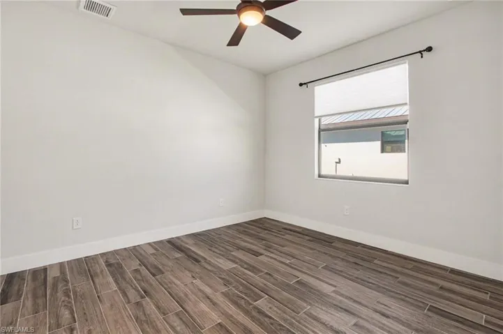 Spare room with wood tiled floors and ceiling fan