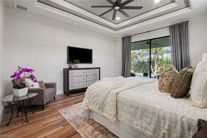 Bedroom with wood finished floors, ornamental molding, ceiling fan, and recessed lighting