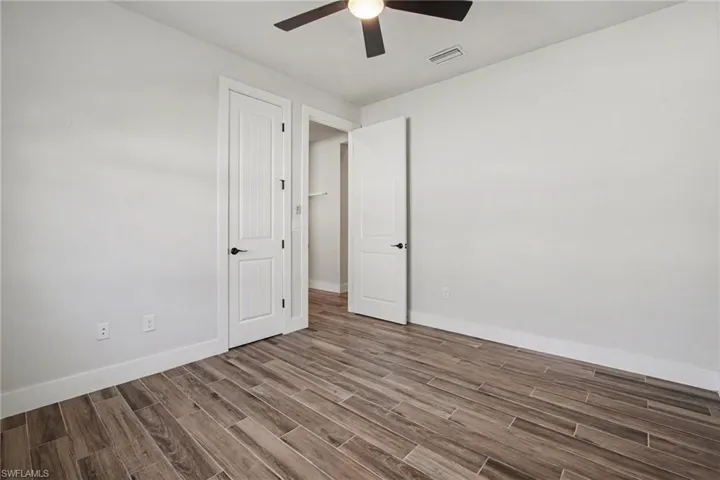 Unfurnished bedroom featuring wood tiled floors and ceiling fan