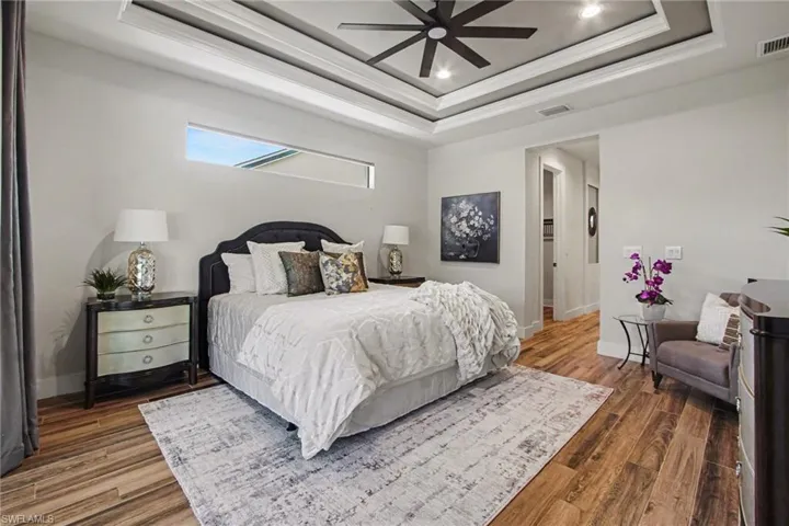 Bedroom with wood finished floors, a ceiling fan, crown molding, and recessed lighting
