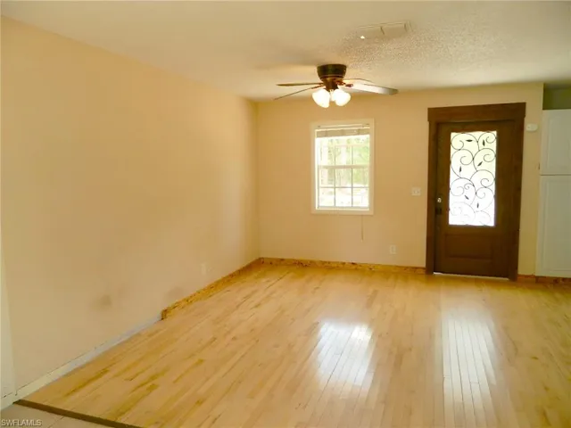 Entryway with a ceiling fan, light wood-style flooring, and baseboards