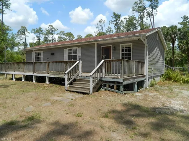 View of front of house featuring a wooden deck