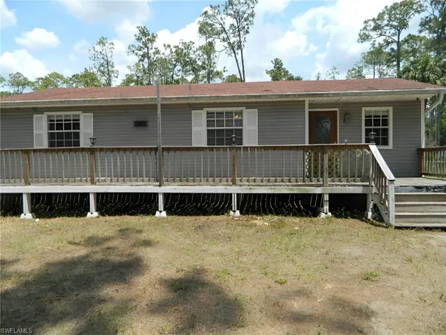 Back of house with a deck