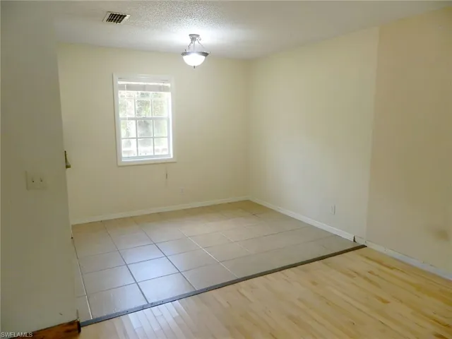 Unfurnished room featuring light tile patterned floors and baseboards
