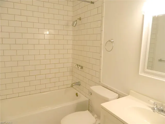 Full bathroom featuring toilet, shower / washtub combination, and vanity
