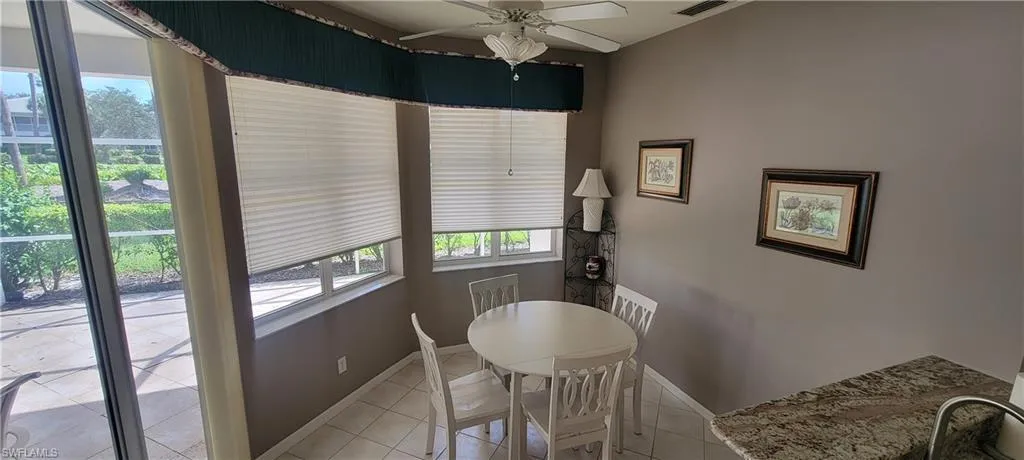 Dining area featuring light tile patterned flooring and ceiling fan