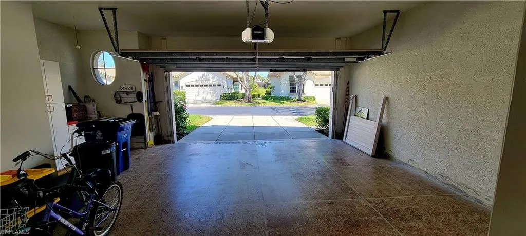 Garage featuring a textured wall and a garage door opener