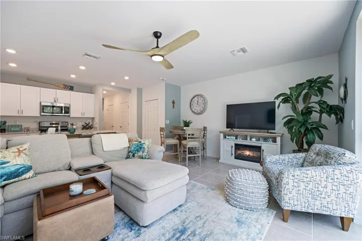 Living room featuring light tile flooring and ceiling fan