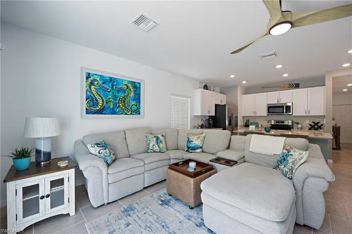 Living room with light tile flooring and ceiling fan
