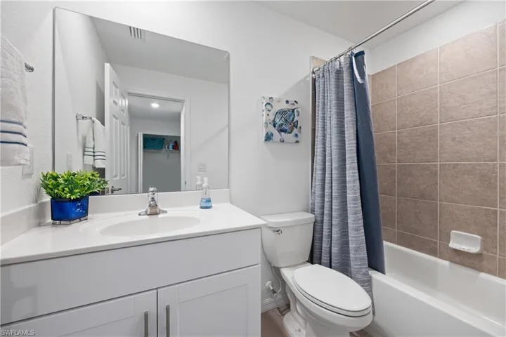 Full bathroom featuring large vanity, toilet, and shower / bath combo with shower curtain