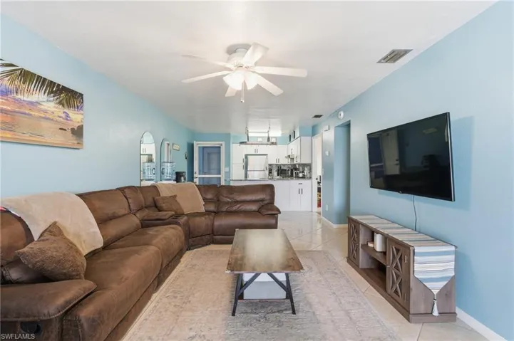 Living area featuring ceiling fan and light tile patterned floors