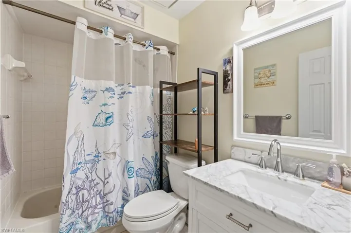 Full bath featuring shower / bath combo and vanity