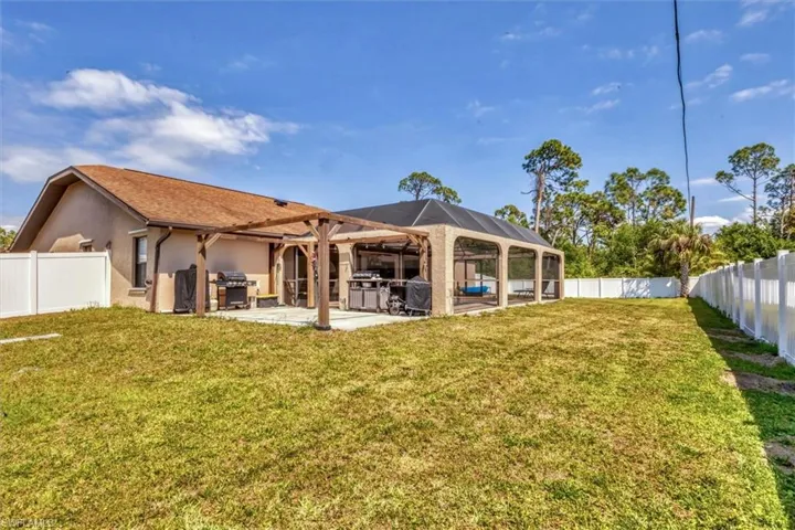 Back of property featuring stucco siding, a lawn, a fenced backyard, and a patio area