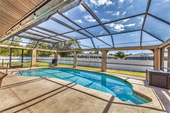 View of pool featuring a lawn, a patio, a fenced backyard, a fenced in pool, and a lanai