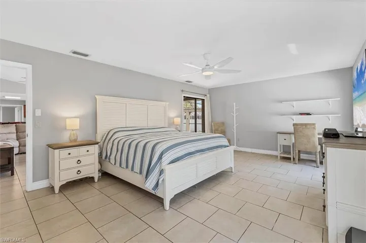 Bedroom with light tile patterned floors, visible vents, baseboards, and a ceiling fan