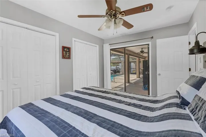 Bedroom featuring ceiling fan, two closets, and access to exterior