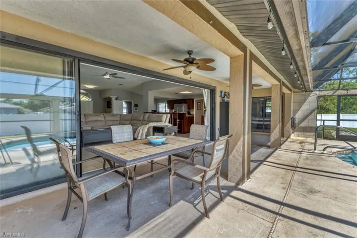 View of patio / terrace featuring outdoor dining space, glass enclosure, fence, and a fenced in pool