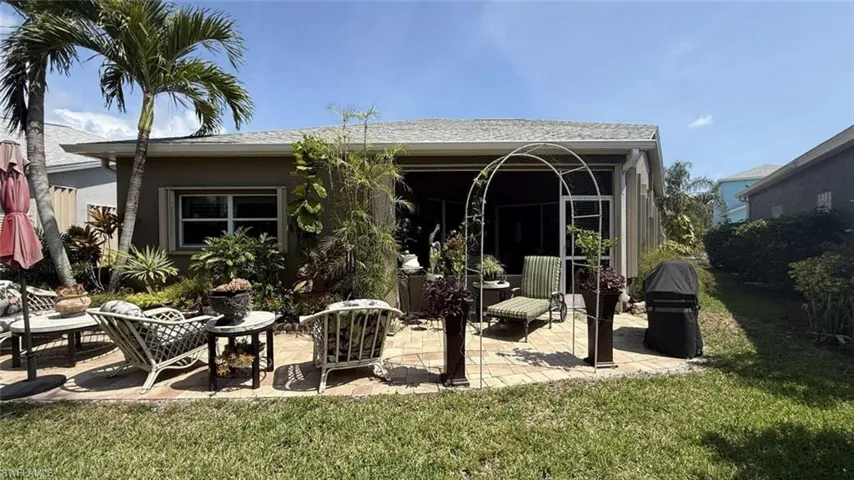 Back of property with a patio and a lawn