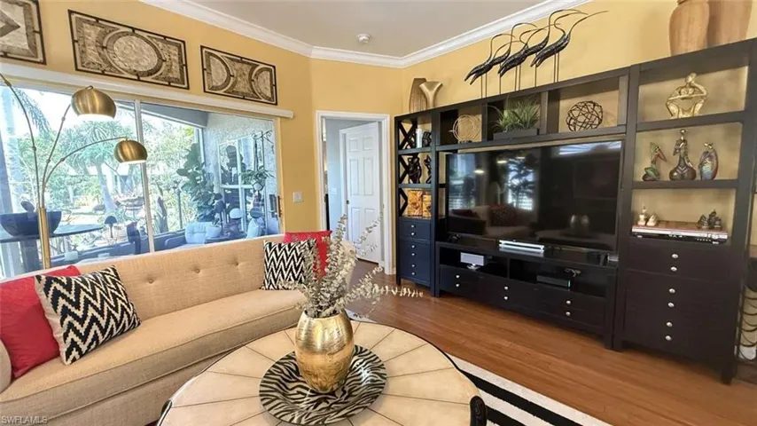 Living area with ornamental molding and wood finished floors