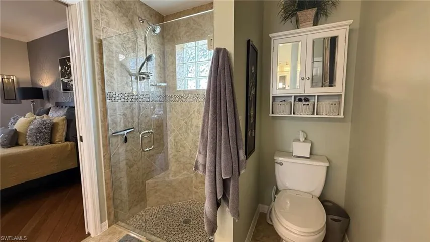 Full bathroom featuring ensuite bath, a stall shower, crown molding, and wood finished floors