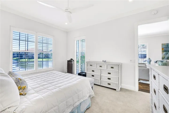 Carpeted bedroom with crown molding and ceiling fan