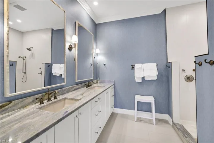 Bathroom featuring vanity, tile patterned floors, crown molding, and walk in shower