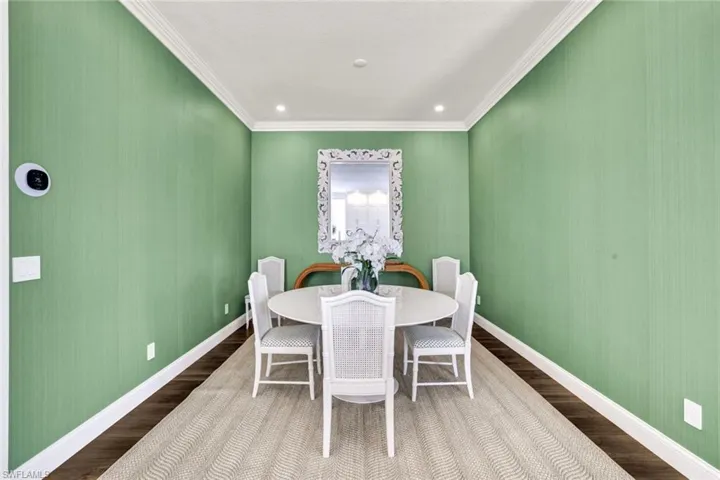 Dining room featuring wood-type flooring and crown molding