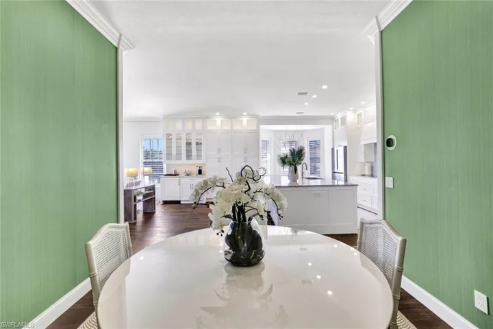 Dining room featuring sink, crown molding, and dark hardwood / wood-style floors