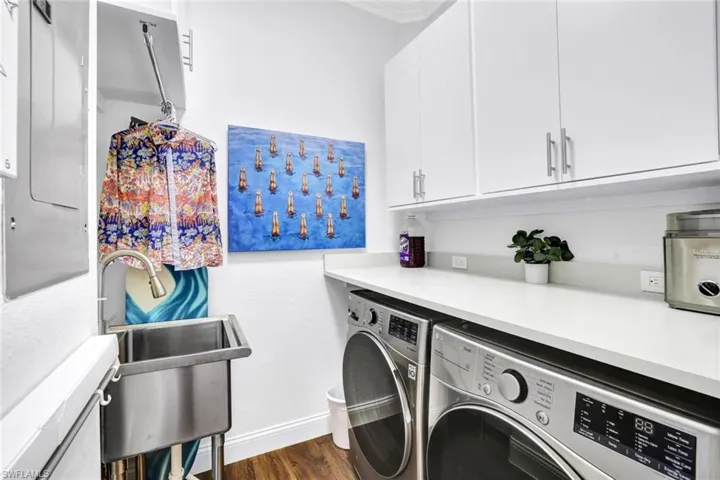 Washroom featuring cabinets, dark hardwood / wood-style flooring, washer and clothes dryer, and sink