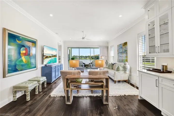 Living room featuring crown molding, a healthy amount of sunlight, and dark hardwood / wood-style flooring