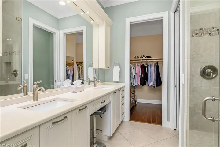 Owner's Bathroom featuring vanity, tile patterned flooring, and an enclosed shower with frameless glass doors.Walk-in-closet.