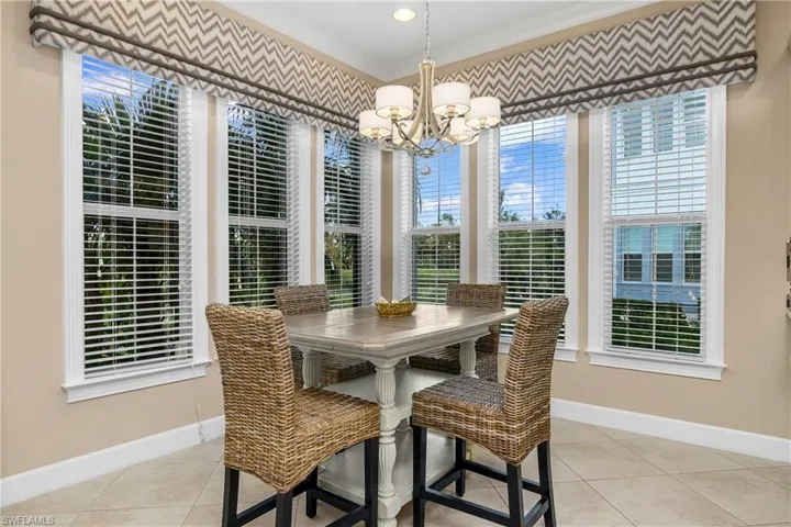 Casual Dining room with light tile patterned flooring, ornamental molding, and a chandelier.