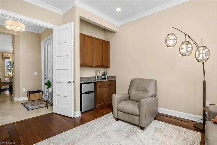 Den / Office  a wet bar, crown molding, and hardwood / wood-style flooring. Removing the wet bar creates another closet if desired.