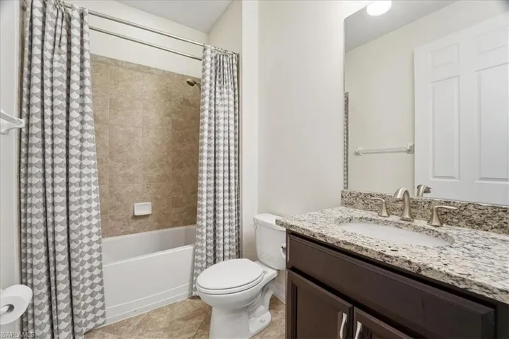 Bathroom featuring vanity and shower / bath combination with curtain
