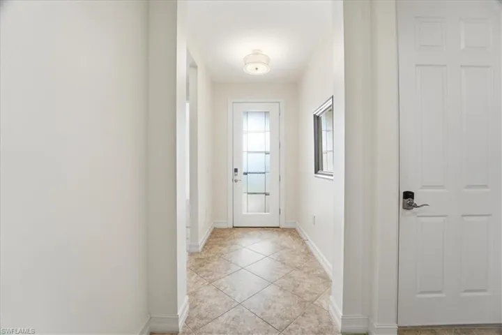 Entryway with baseboards and tile patterned flooring