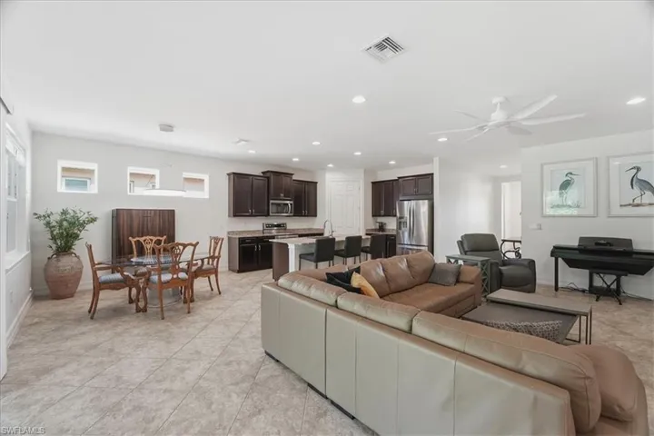 Living room featuring a ceiling fan, light tile patterned floors, and recessed lighting