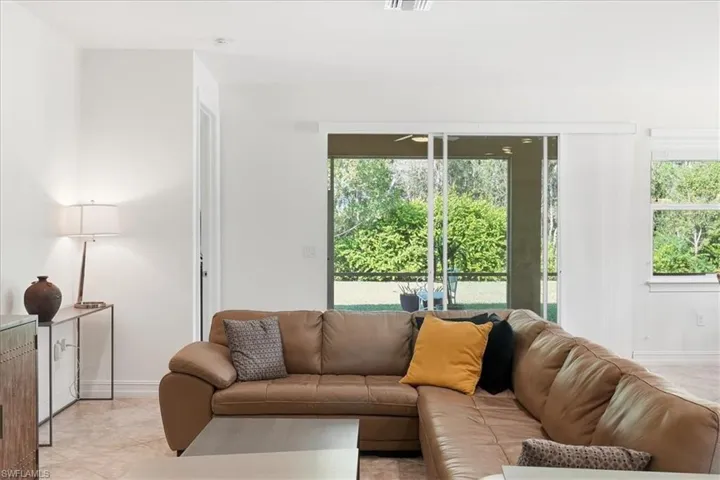 Living room with healthy amount of natural light and light tile patterned floors