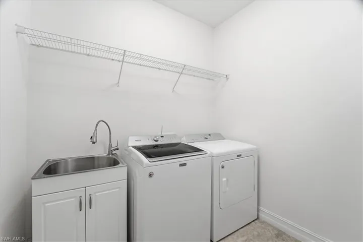 Laundry area with a sink and washing machine and clothes dryer