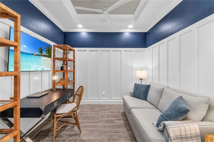 Office featuring wood tiled floor, a decorative wall, and crown molding